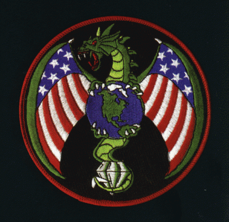El satélite espia está simbolizado por un dragón enojado agarrando todo el planeta con sus cuatro garras y un diamante en su cola. No parecen preocupados por nuestra privacidad.